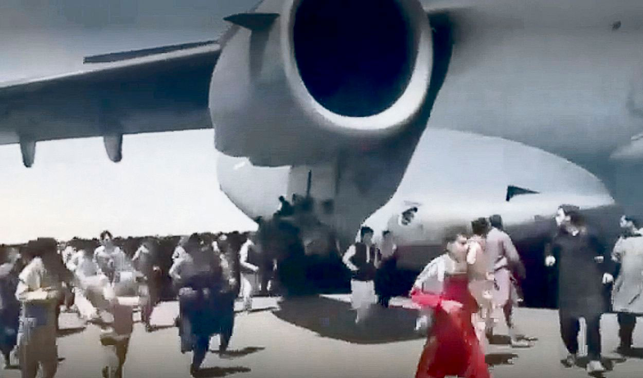 Pánico. Decenas de personas despavoridas intentaron subirse a un avión estadounidense que iba en movimiento en el aeropuerto de Kabul. Foto: captura de video de EFE