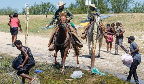 Las imágenes muestran a agentes de la Patrulla Fronteriza montados en sus caballos agitan sus látigos para que los migrantes desistan de cruzar el río. Foto: Paul Ratje / AFP