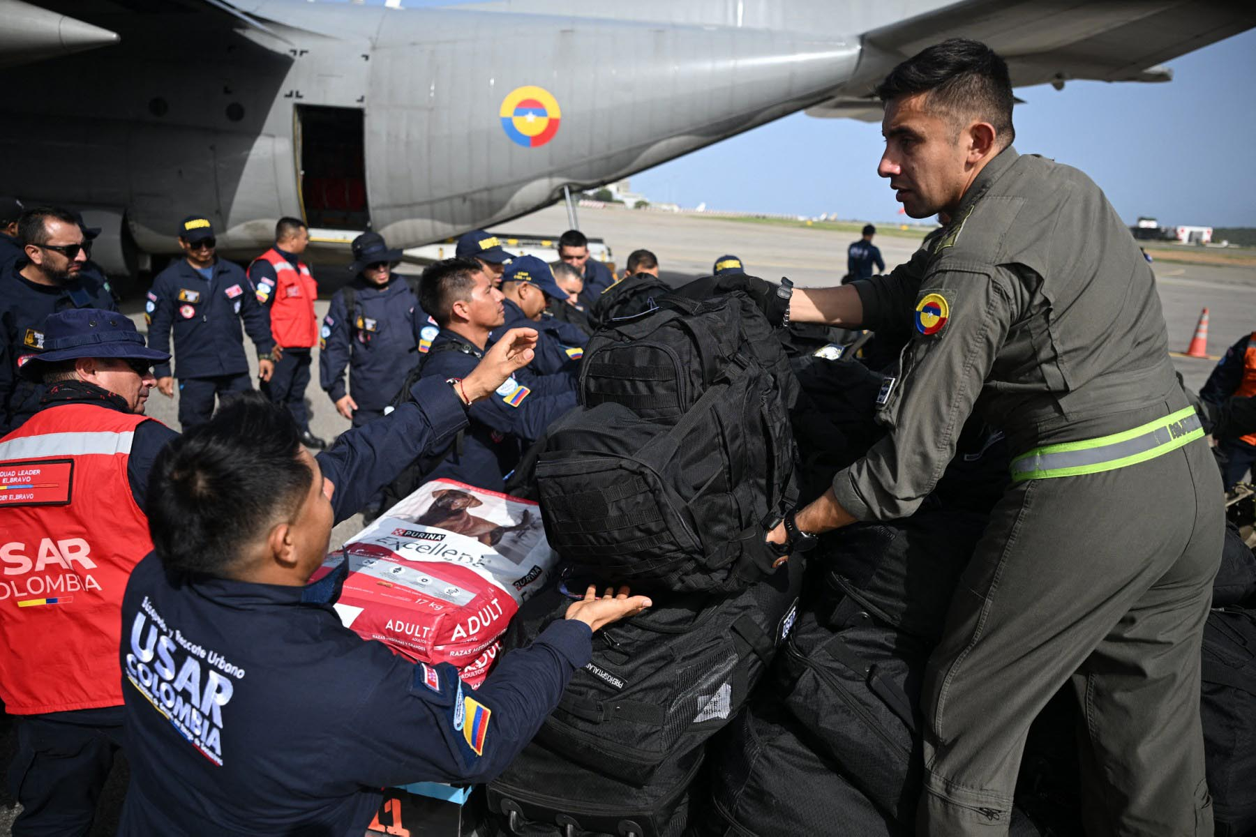 Miembros del equipo colombiano de Búsqueda y Rescate Urbano (USAR) descargan equipo a su llegada al aeropuerto internacional Simón Bolívar en La Guaira