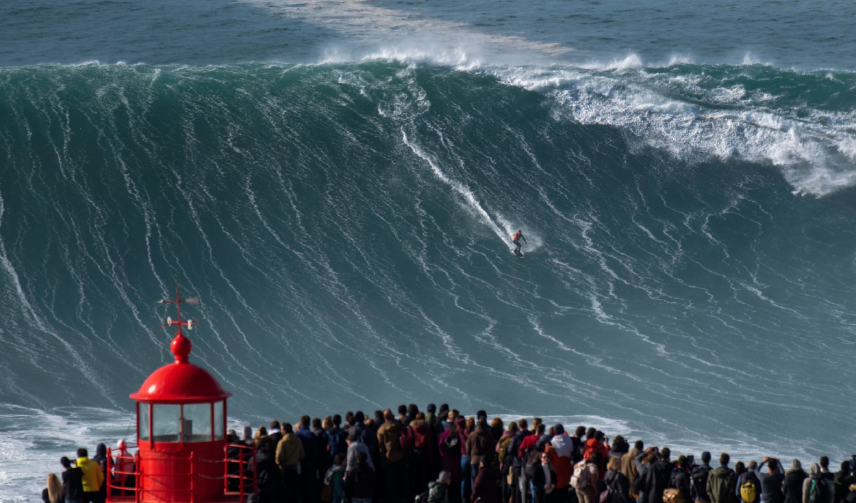 Un surfista cabalga una ola de entre 15 y 20 metros de altura en Portugal. Foto: AFP