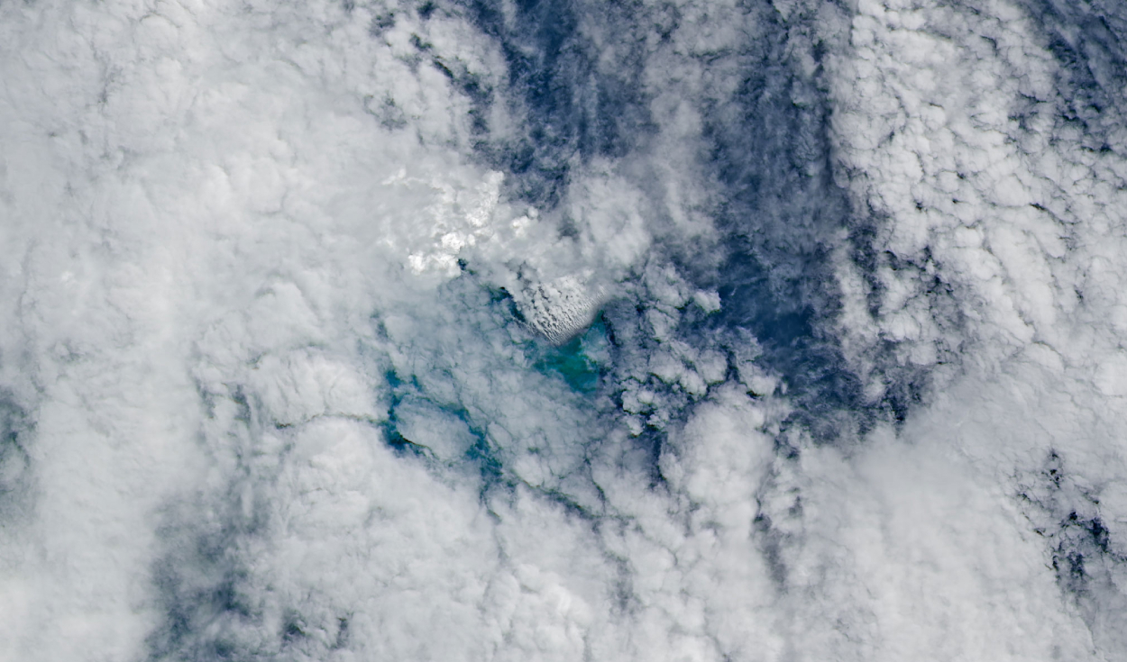 Columnas volcánicas muy próximas entre sí, rodeadas de nubes, emanan de una plataforma volcánica submarina en expansión. Foto: NASA Una erupción submarina al norte de Papúa Nueva Guinea podría estar creando nueva tierra
