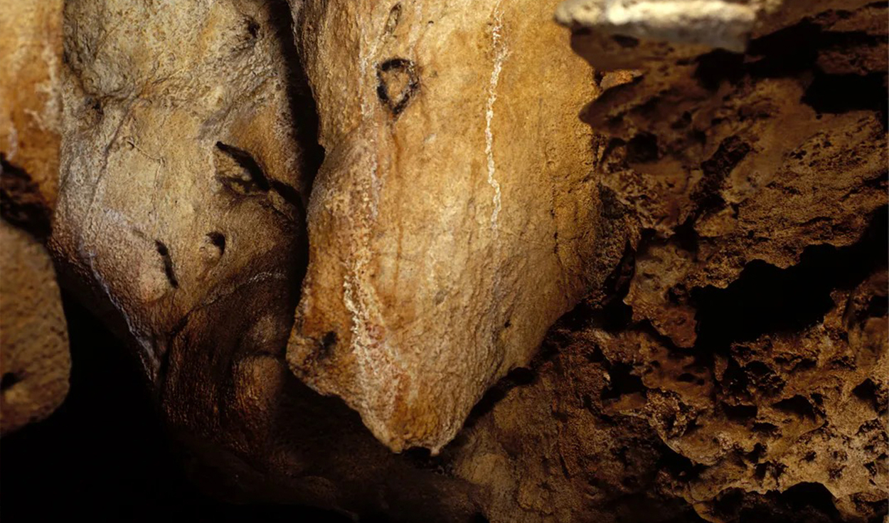 En un saliente rocoso que recuerda a la cabeza de un bisonte en El Castillo, un artista prehistórico realizó sencillas marcas para evocar ojos y una fosa nasal. Foto: Gobierno de Cantabria/Pedro Saura Ramos
