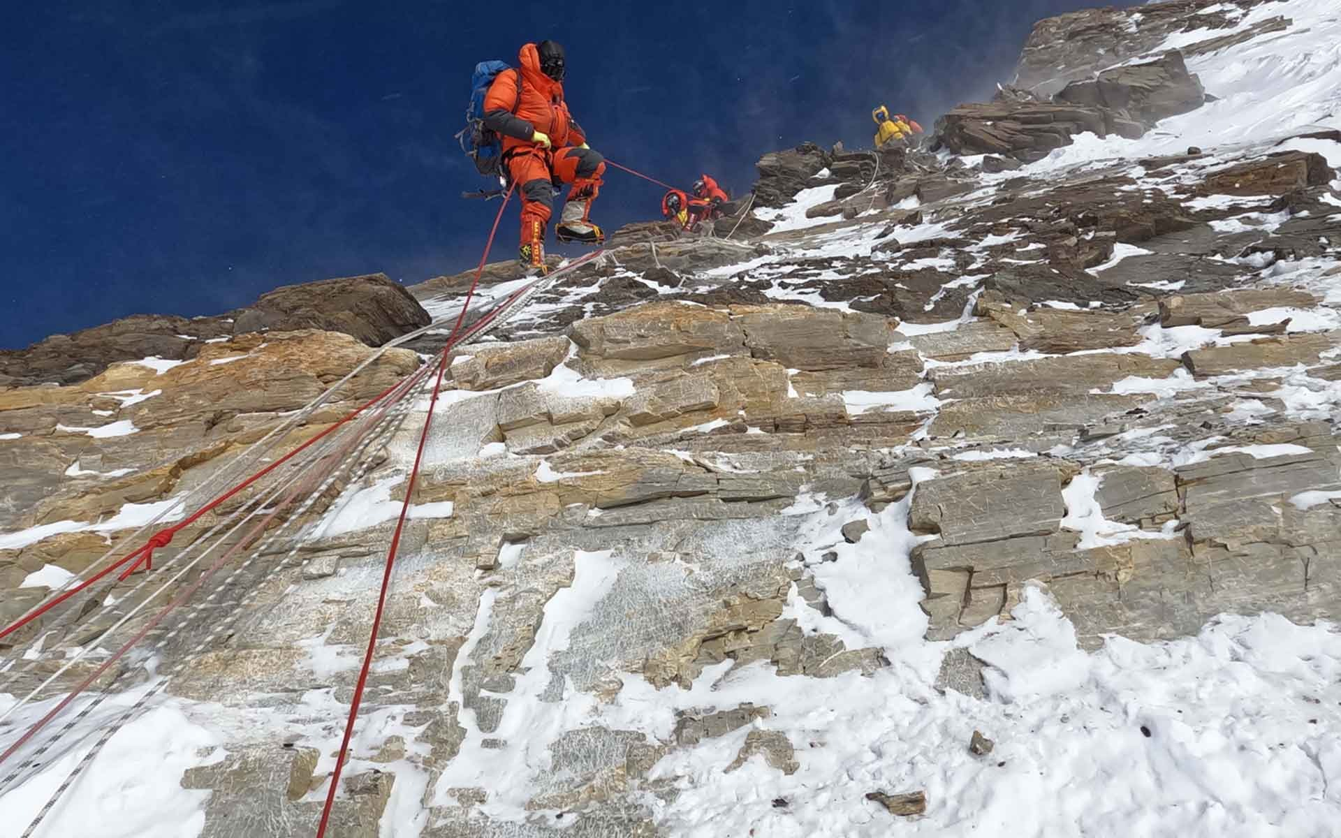 Los escaladores atraviesan las calizas de color gris pálido y marrón claro cerca de la cima, a 8500 m de altitud, donde se observan ciclos de calizas de plataforma y dolomitas perimareales. Foto: Luis Carcavilla/IUGS